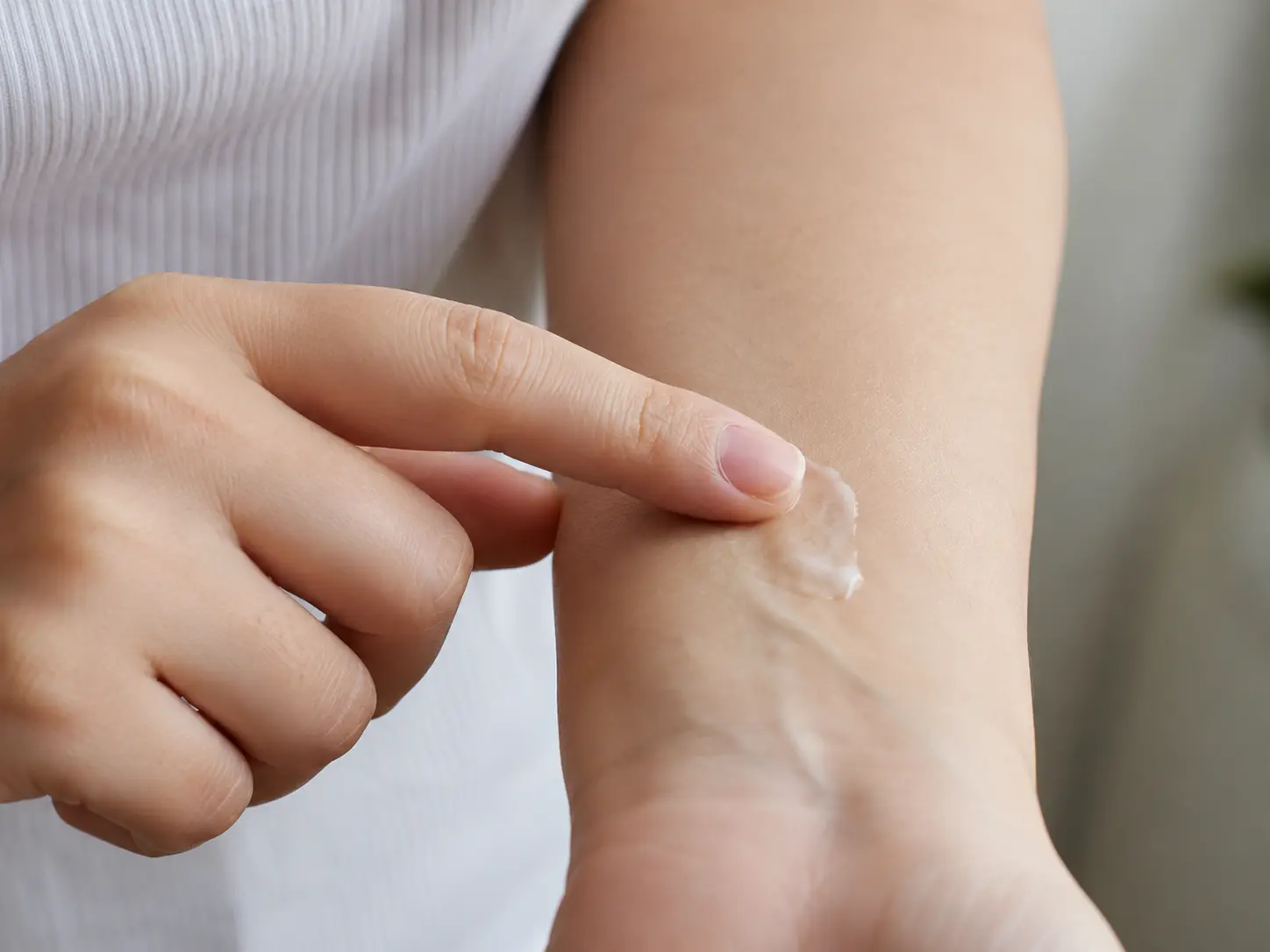 Patch testing new skincare product on inner arm before applying to face