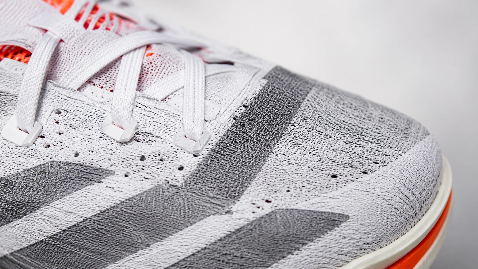 Close-up of Adidas Prime X3 STRUNG upper showing woven performance material texture