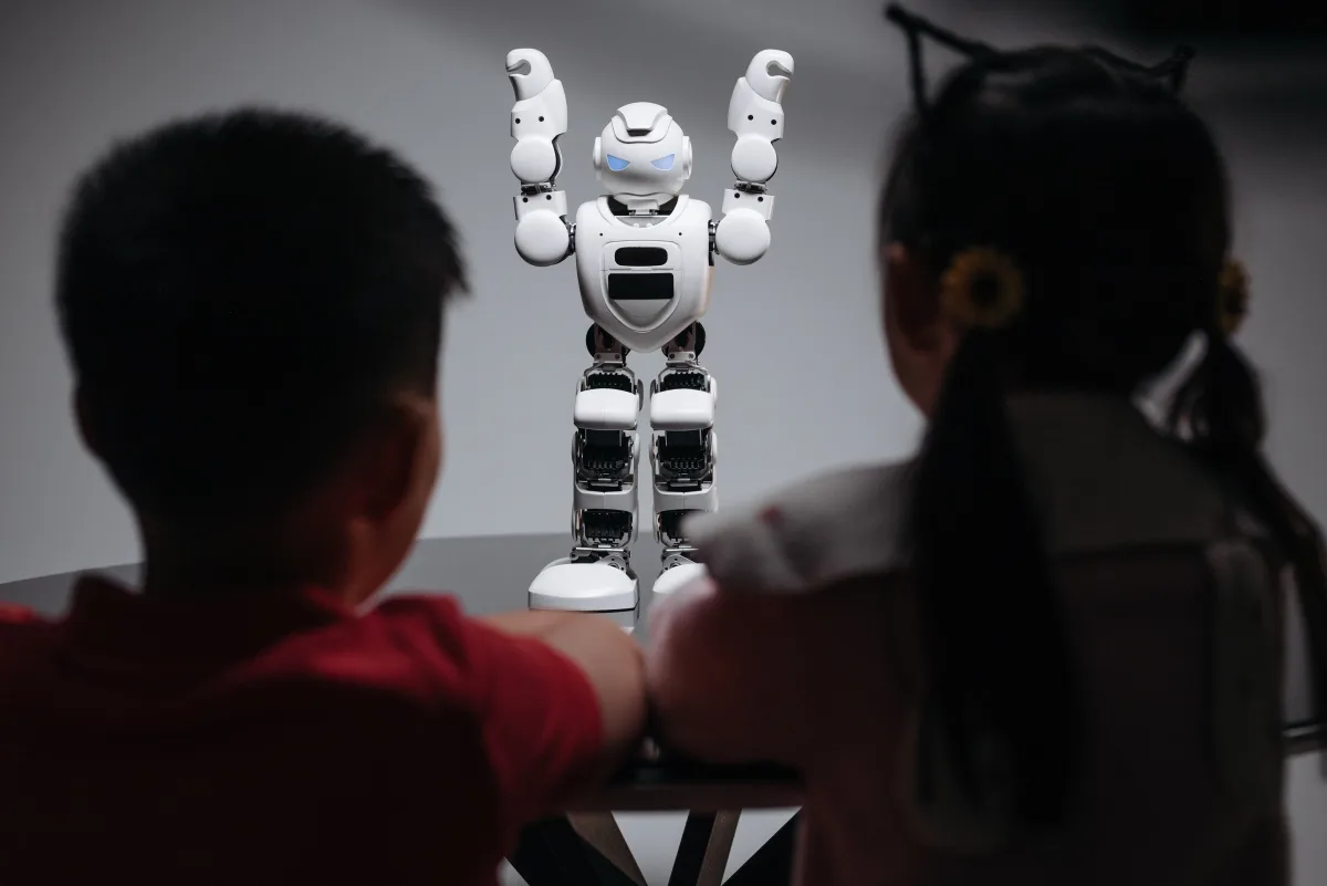 Two children observing a humanoid robot — best STEM toys tweens ages 9 to 13 Spintronics Sphero 2026