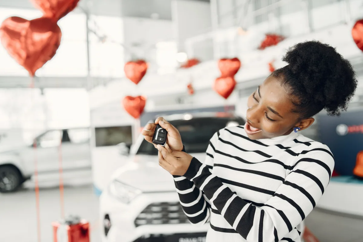 Happy woman holding car keys after completing a car purchase