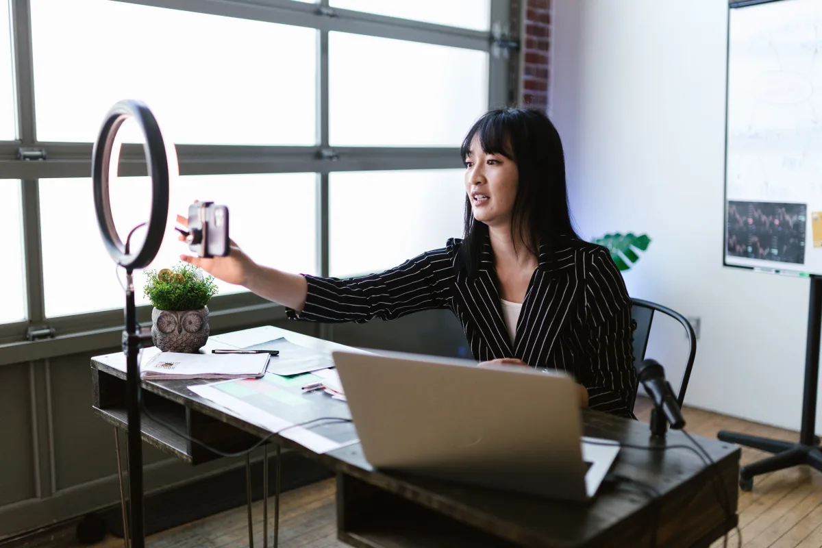 Person at a home office desk with monitor and webcam