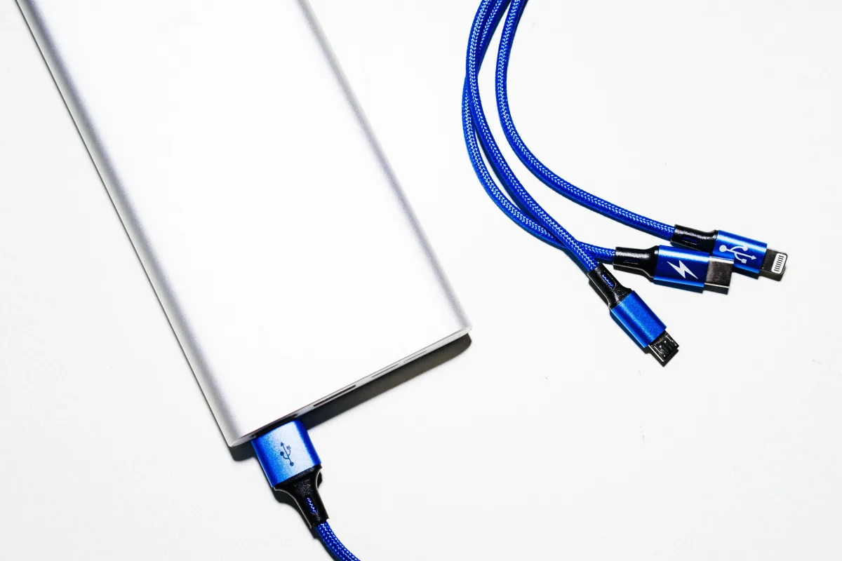 Compact power bank with USB-C and USB-A charging cables on white surface