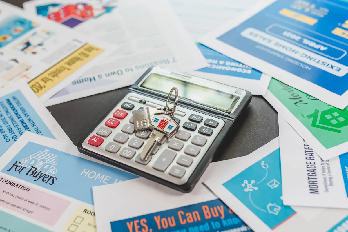 Calculator and real estate paperwork on desk for mortgage planning