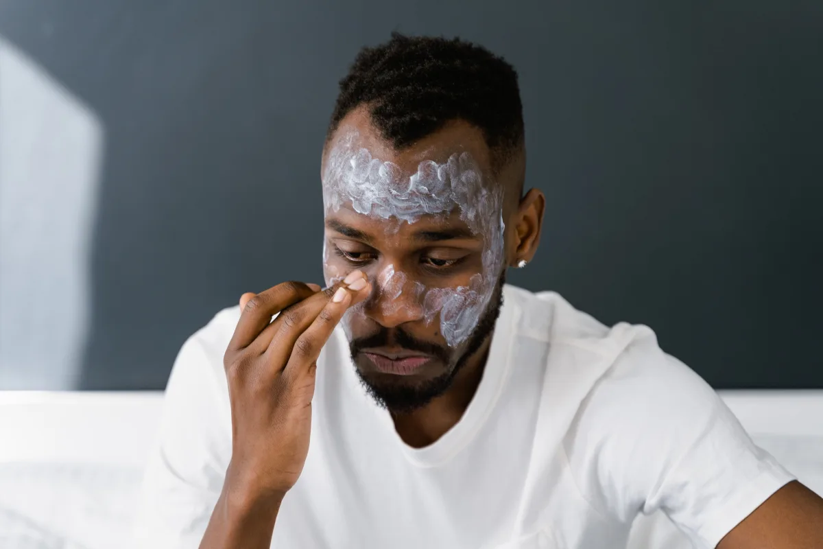 African American man applying face cream for daily skin health
