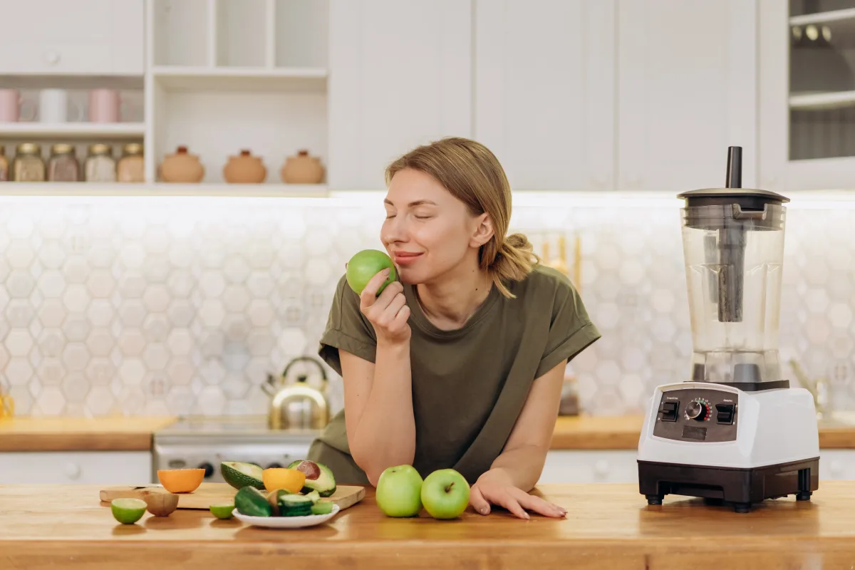 Person holding a NutriBullet personal blender cup with fresh berry smoothie