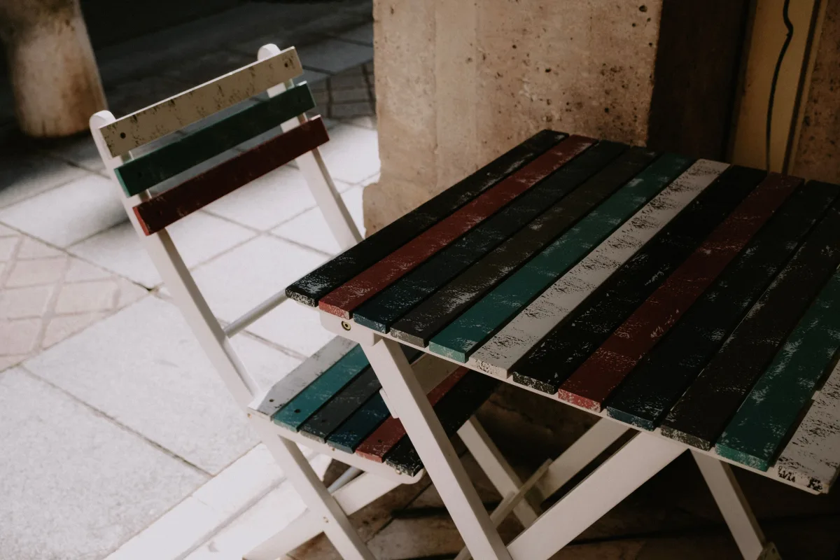 Colorful outdoor cushion set on bistro furniture against stone wall