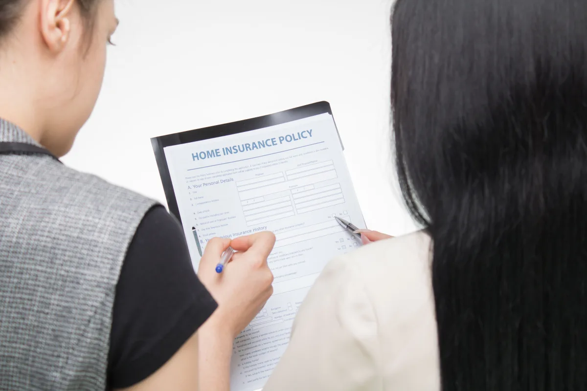 Two people carefully reviewing a renters insurance policy form