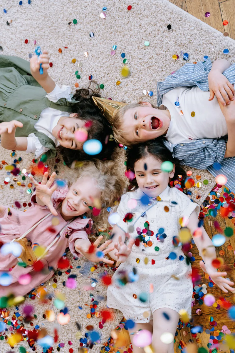 Children laughing and playing at a colorful birthday party