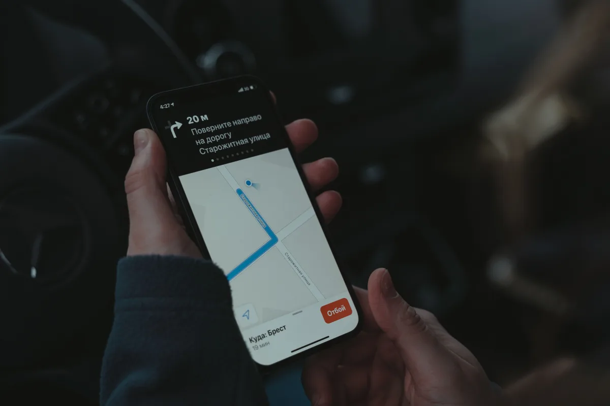 Hand holding smartphone with location tracking map app on screen