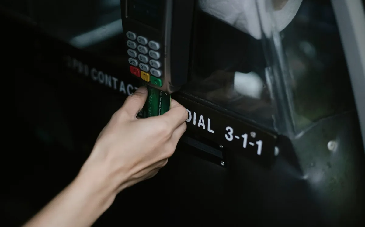Person tapping a contactless credit card on a payment reader inside a vehicle