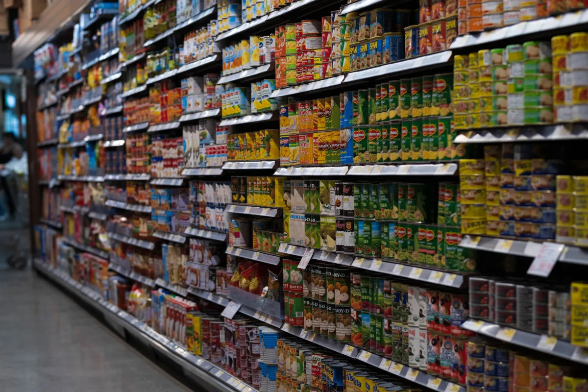 Organized grocery store shelves with rows of canned and packaged food