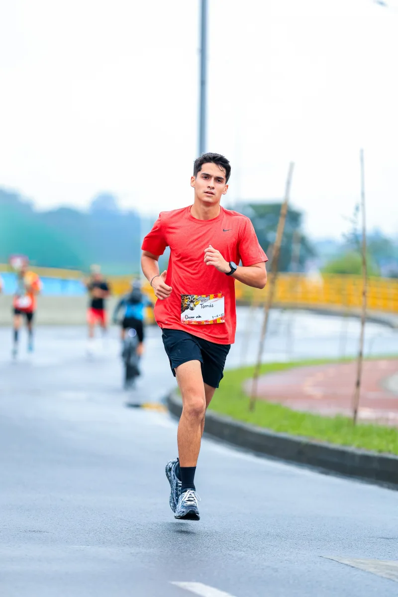 Young male athlete running in outdoor marathon wearing running shoes