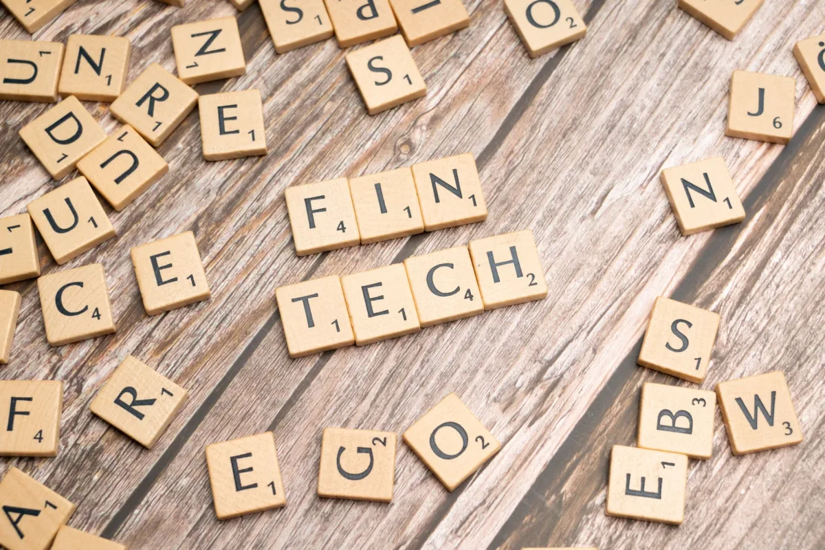 Fintech spelled out with wooden letter tiles on a wooden background
