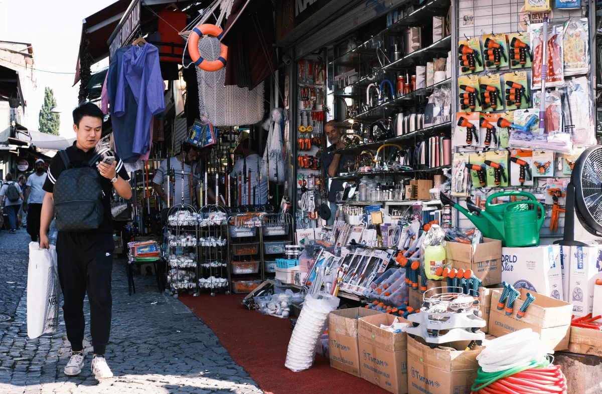 Man browsing tools at an outdoor electronics market stall