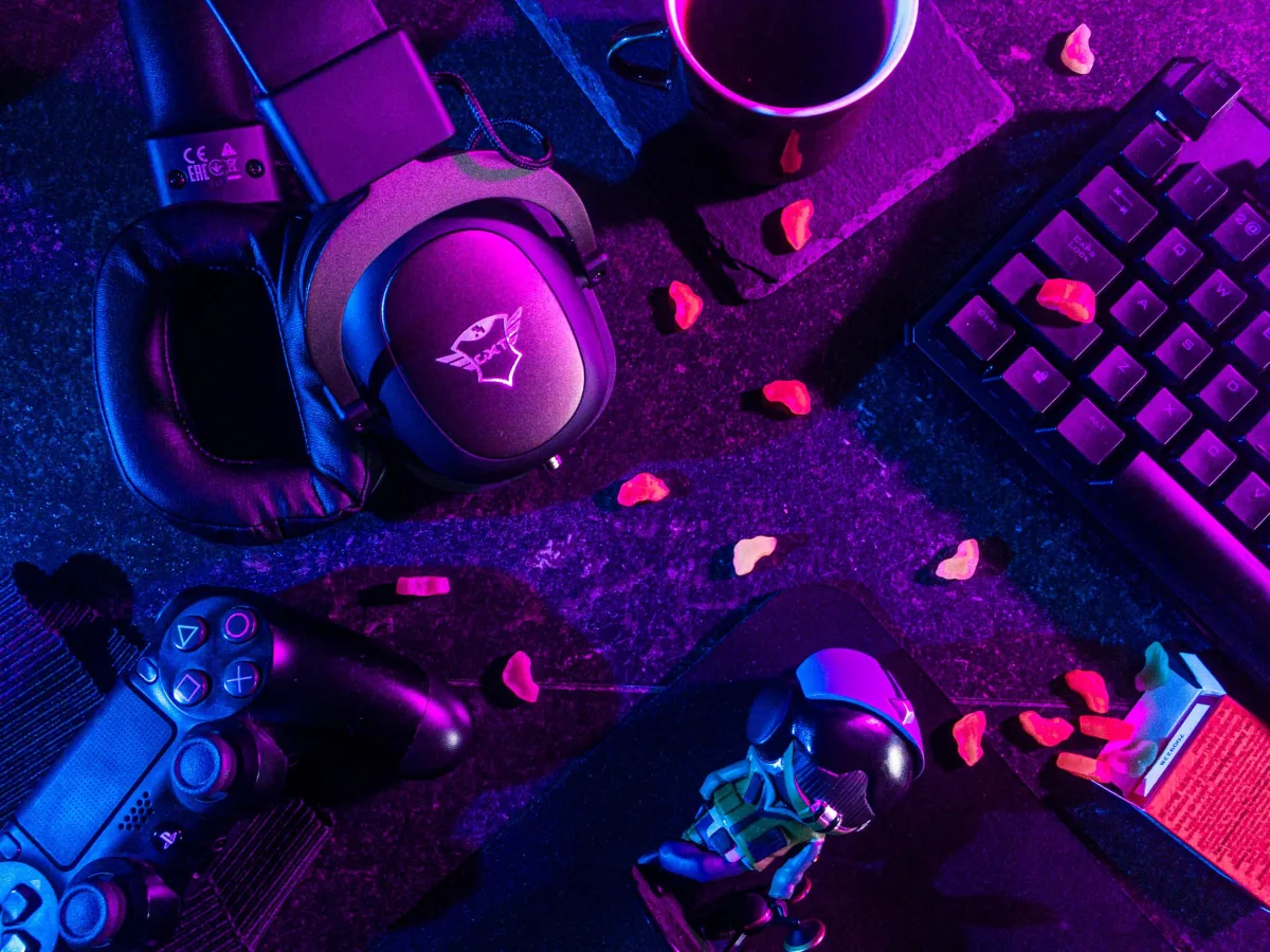 Colorful flat lay of gaming gear including headset, controller, and keyboard