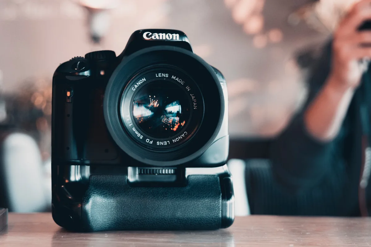 Person shooting with Canon DSLR camera — beginner photography equipment