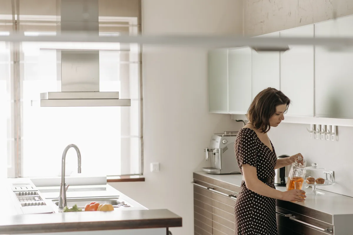 Woman pouring water in a contemporary home kitchen