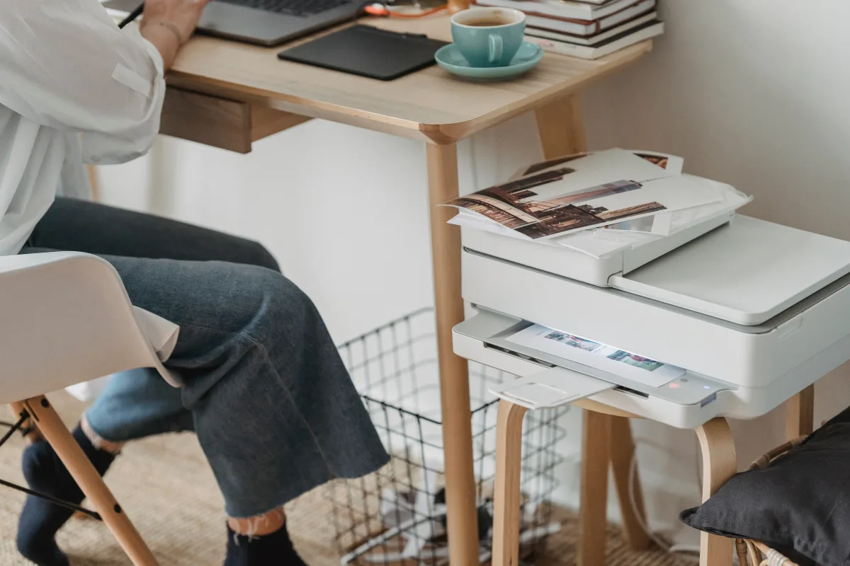 Woman working at home printing photos from a laptop