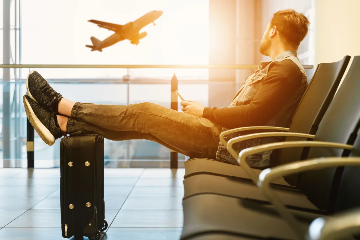 Man at airport terminal waiting to board — airline loyalty program