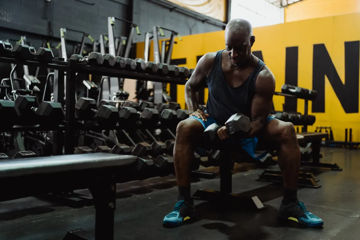 Man lifting dumbbells in home gym — strength training 2026