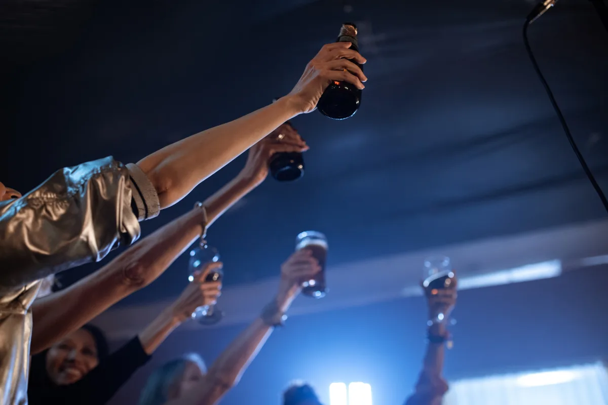 Group of friends raising wine glasses in celebration at a bar