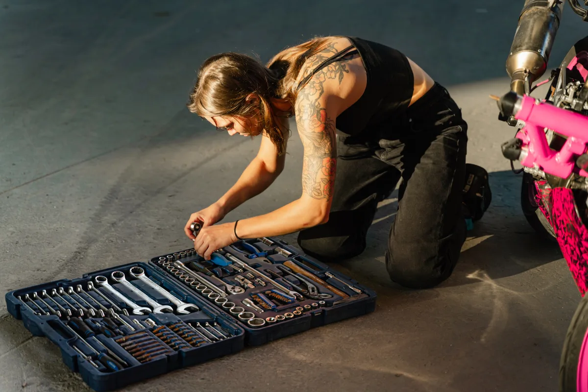 Person organizing hand tools from a toolbox in garage setting