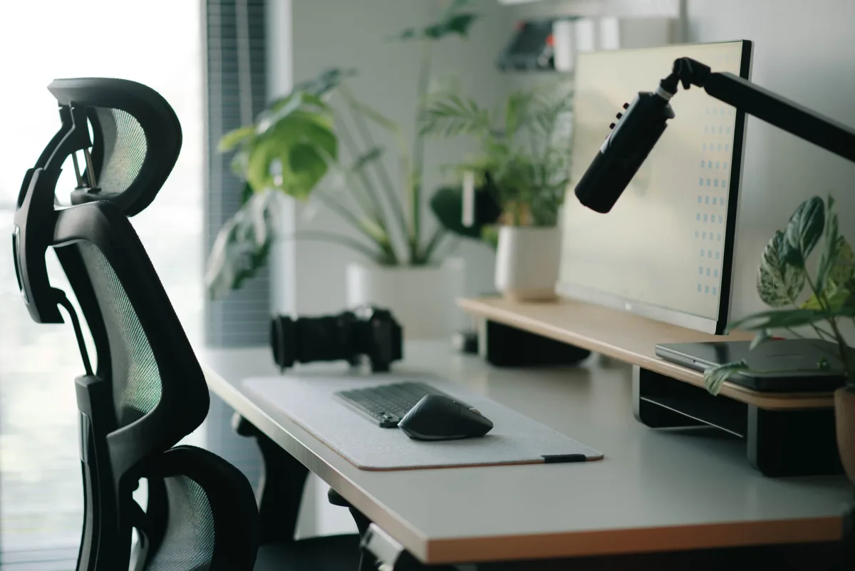 Stylish home office setup with ergonomic chair, plants, and modern tech accessories