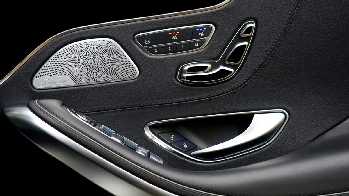 Luxury car interior door panel with control buttons and speaker grille