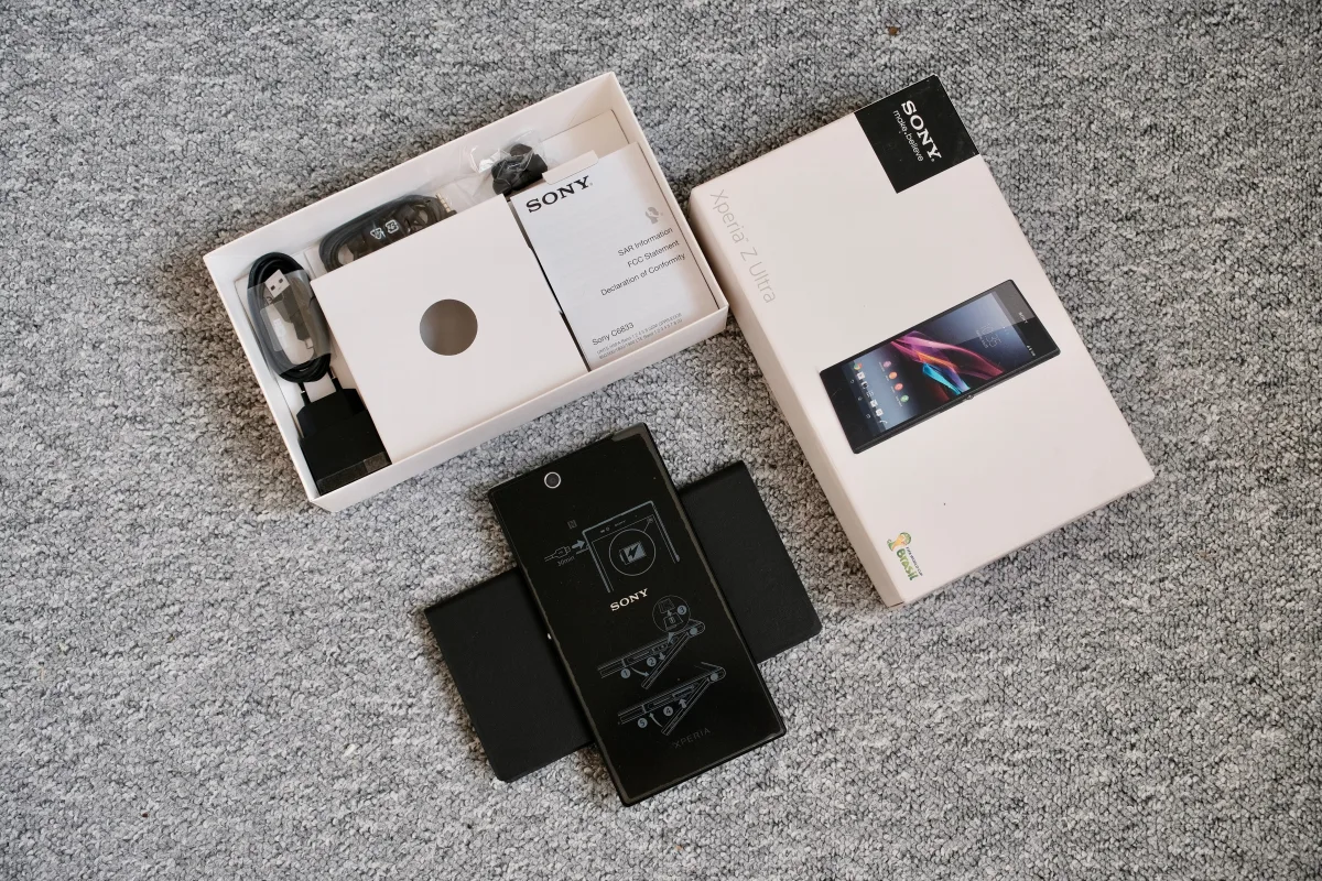 Unboxed mobile phone and accessories laid out for review