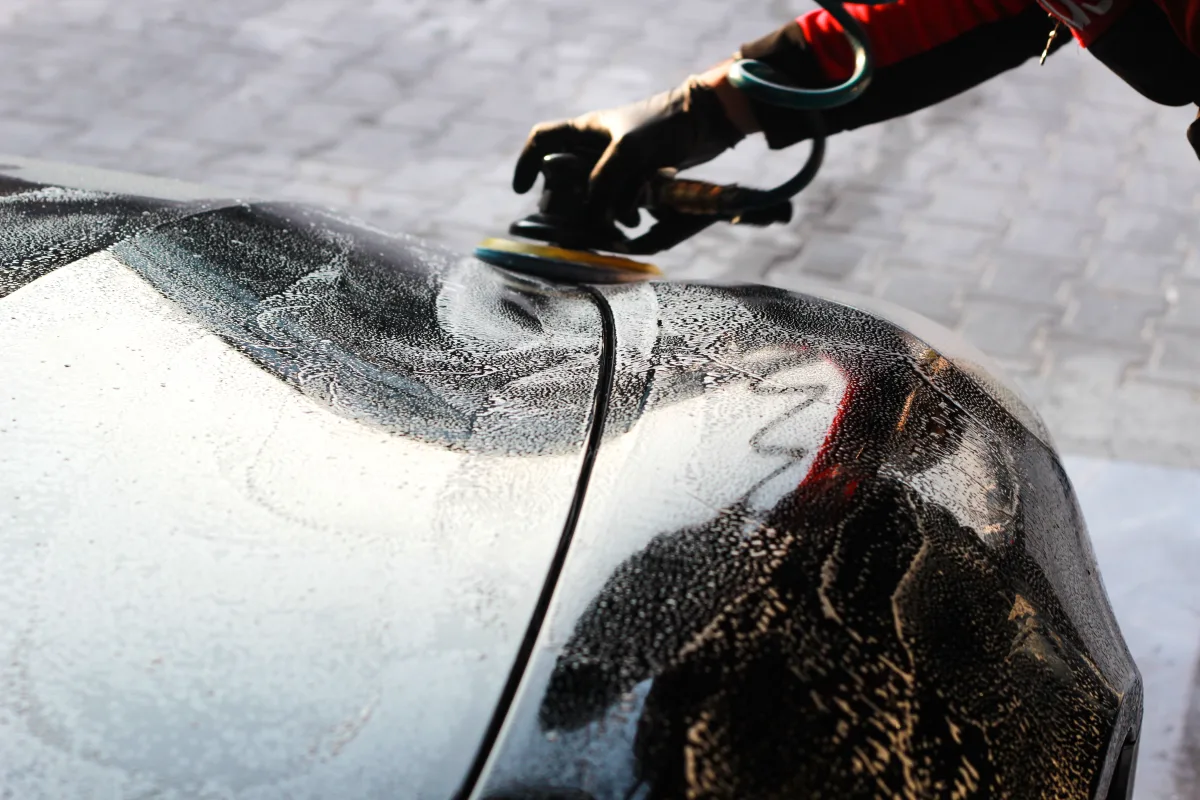 Person waxing a car (hand + cloth, close-up)