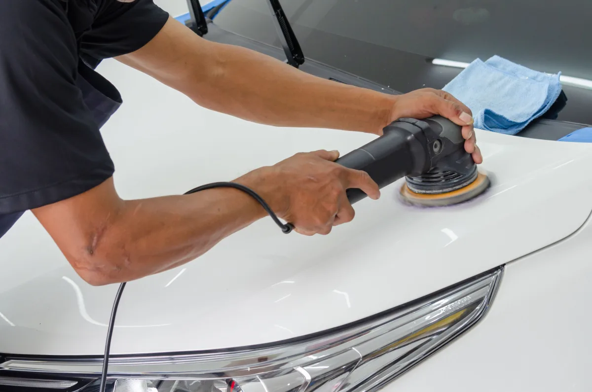 Rotary polisher on white car hood