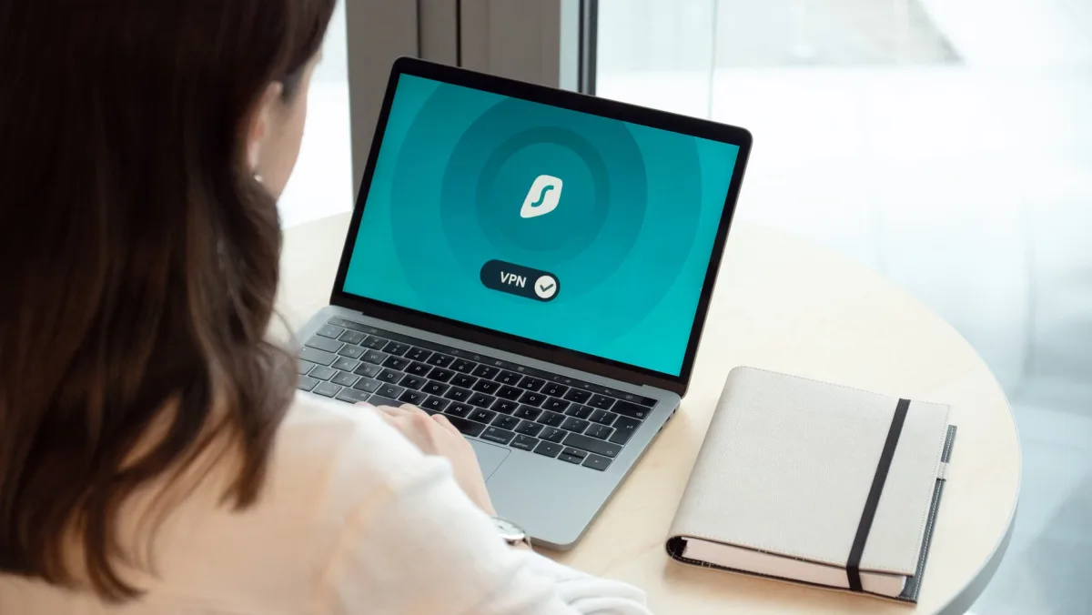 Woman working on a laptop with a VPN security app on screen