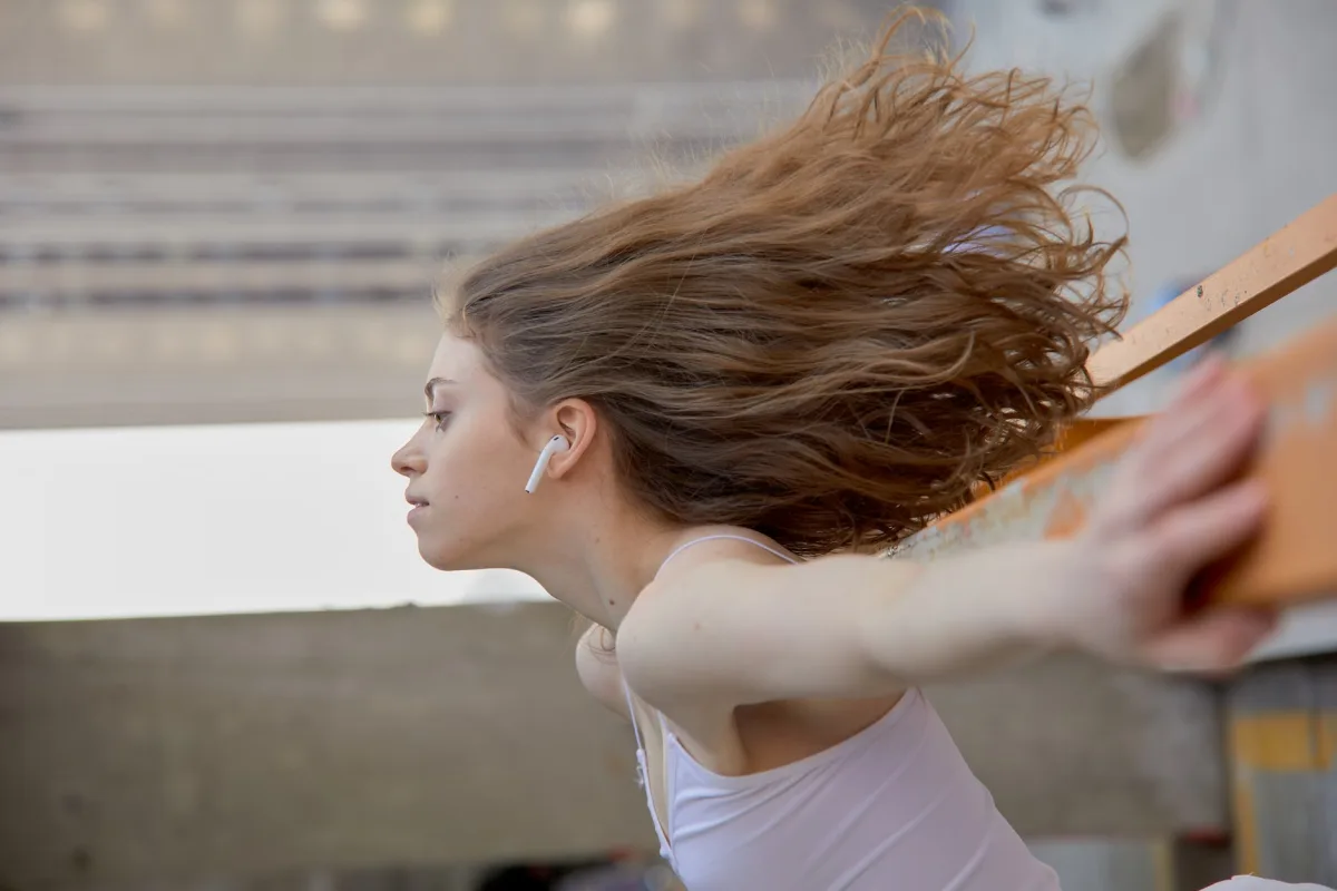 Woman wearing wireless earbuds in motion outdoors