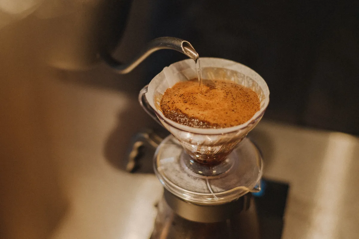 Close-up of pour-over coffee preparation in a café — single serve and pod coffee makers 2026