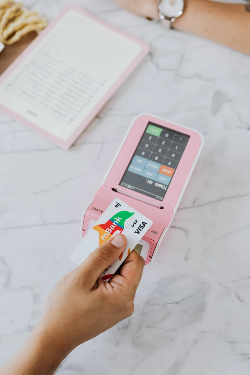 Person paying with credit card at store checkout — loyalty rewards moment