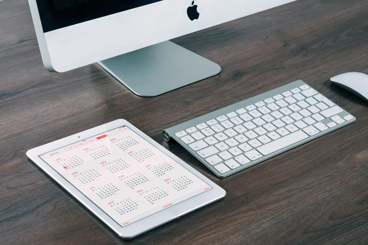 Tablet and iMac set up side by side on a desk, representing a 2026 home office