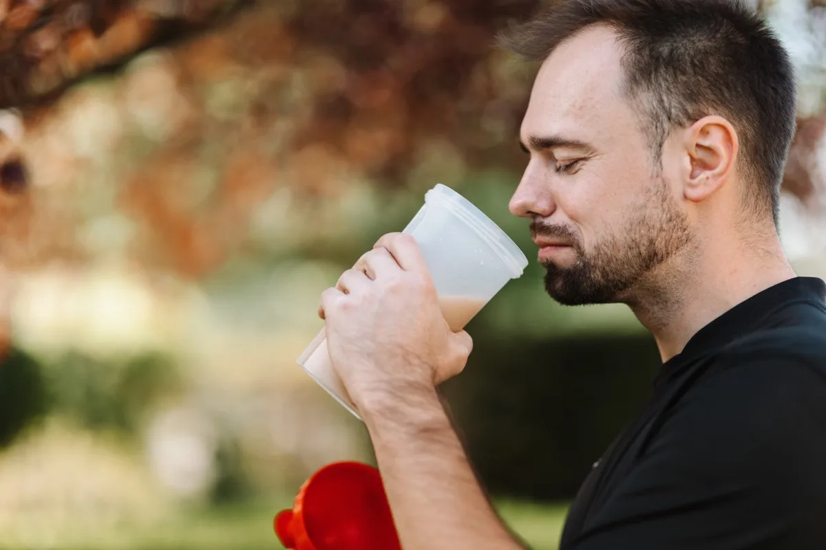 Man with protein shake in outdoor setting