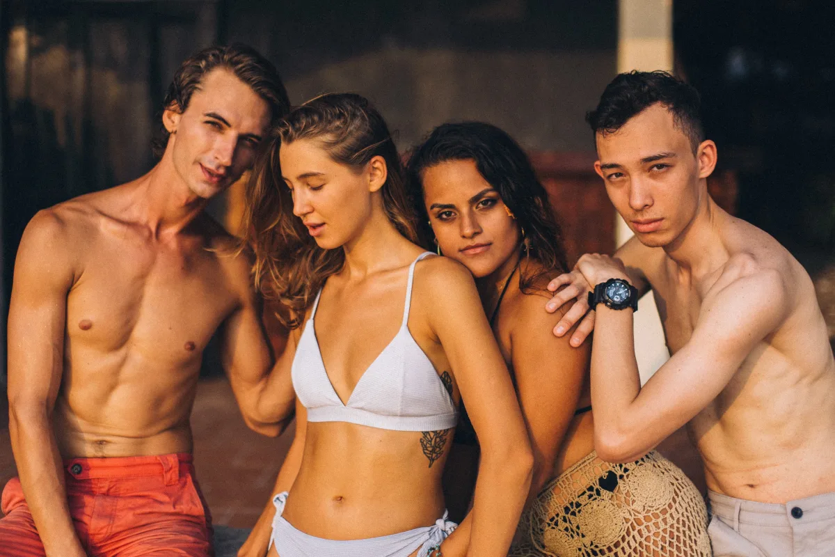 Stylish women posing in swimwear in sunny outdoor setting