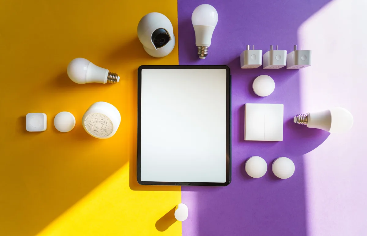Top view of smart home devices and tablet on split yellow purple background — choosing smart home ecosystem 2026