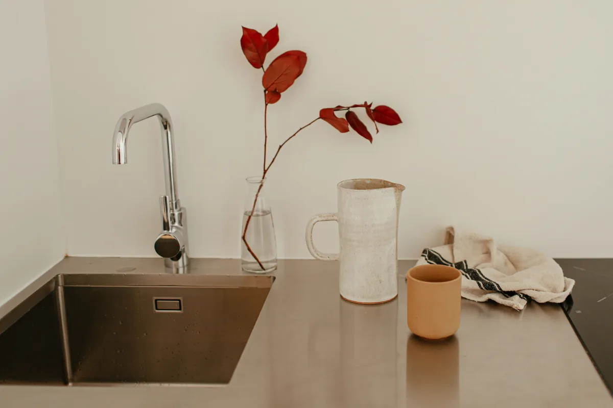 Modern kitchen sink with ceramic pitcher and clean countertop