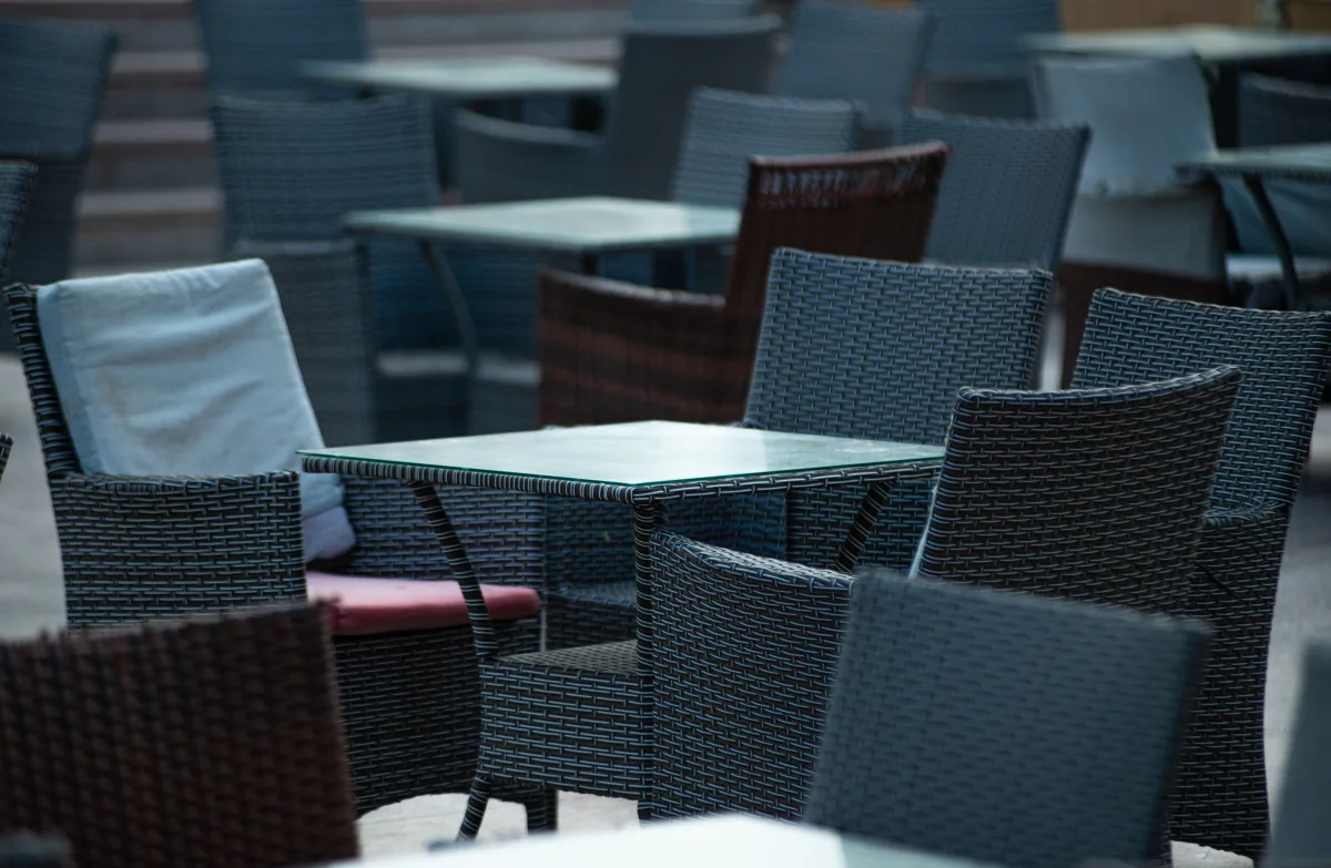 Wicker chairs and tables on outdoor café terrace — all-weather resin wicker furniture