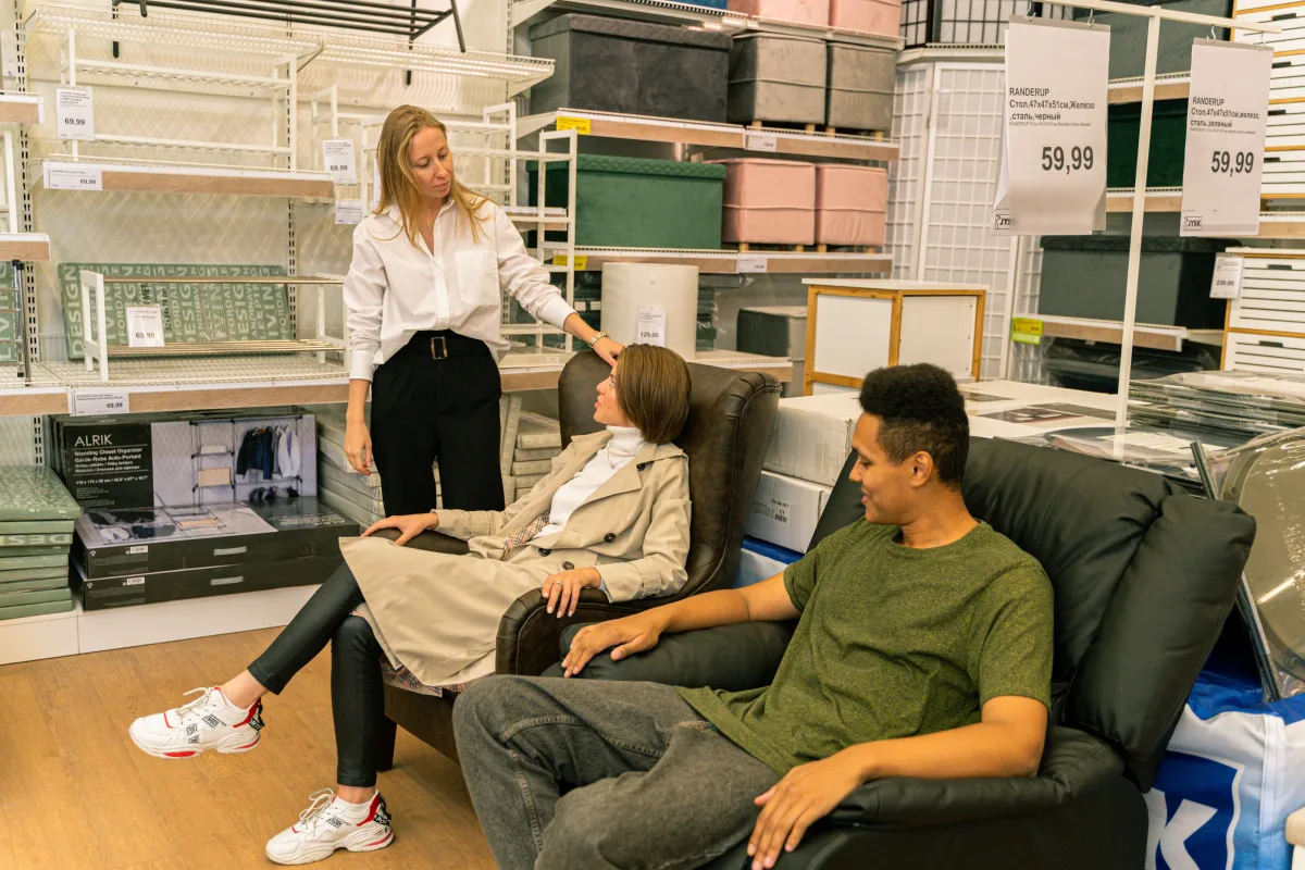 Customers testing leather chairs in a home furnishings store