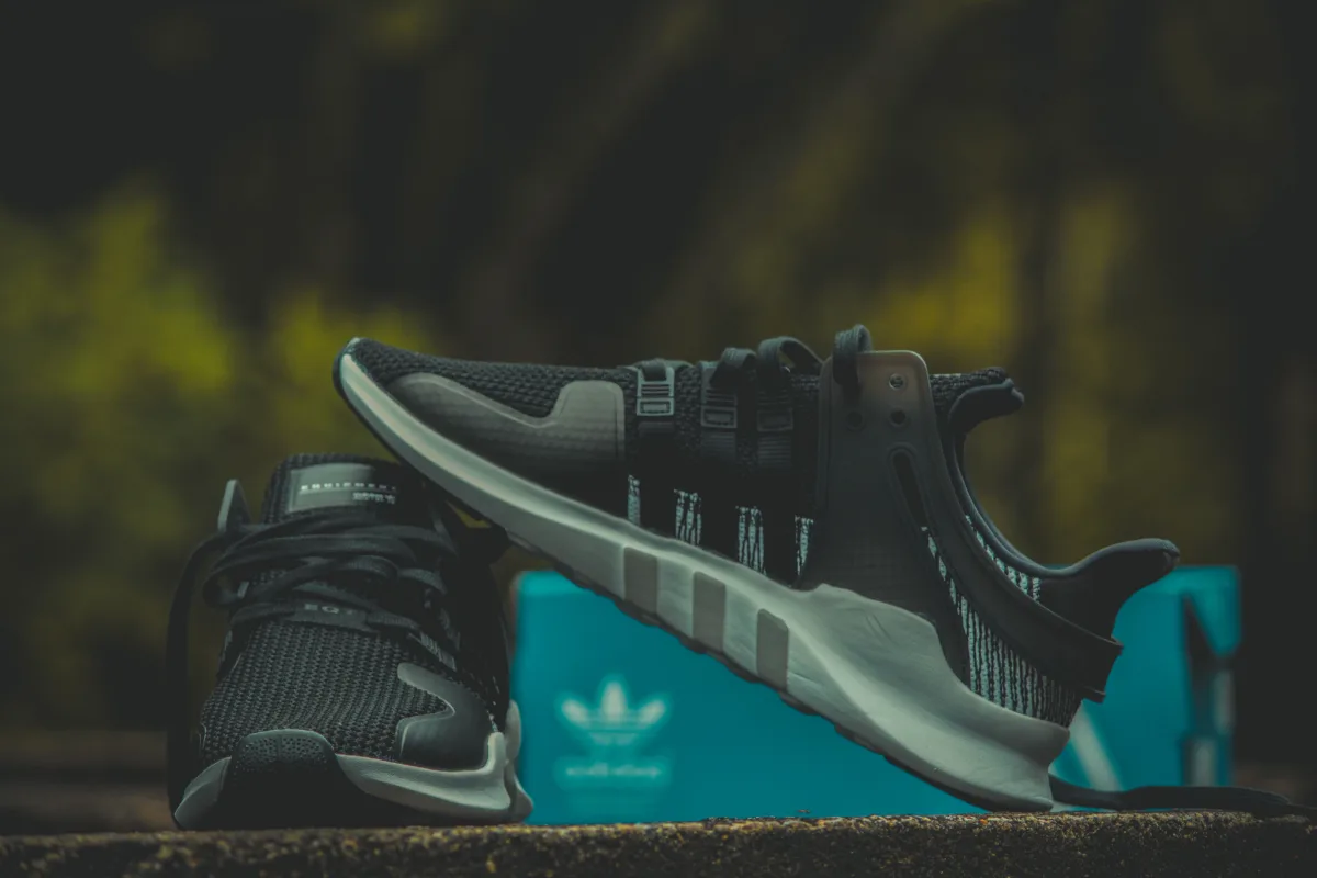 Black Adidas sneakers in branded shoe box — lifestyle product shot