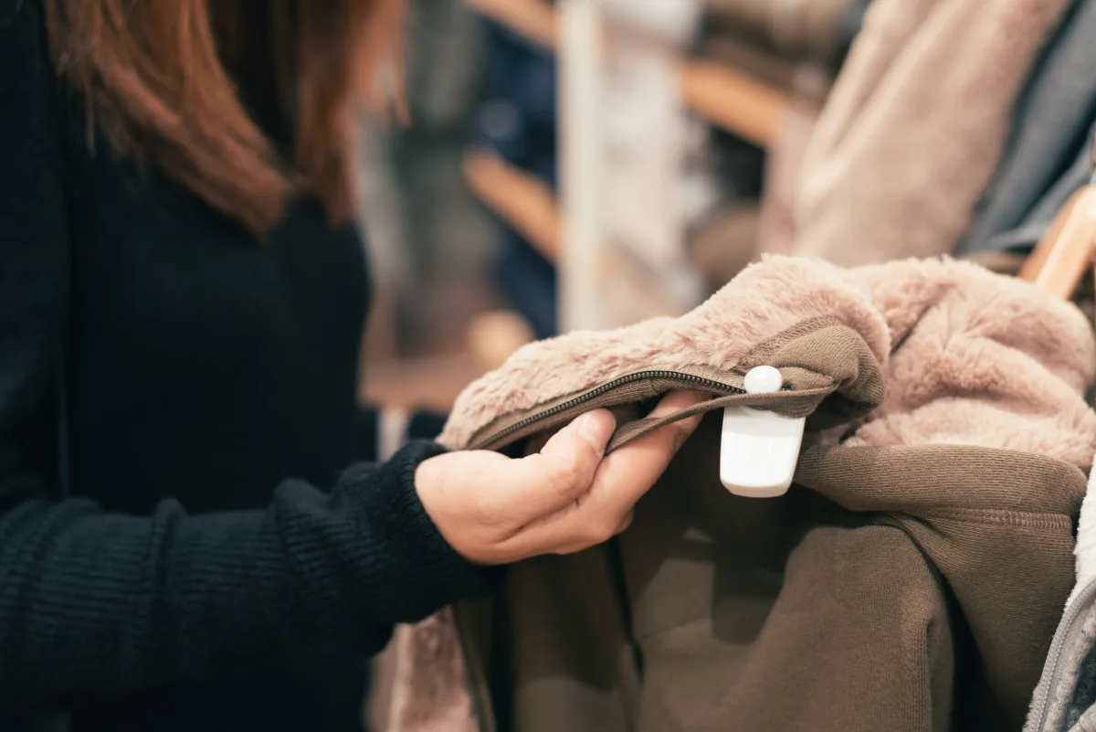 Close-up of woman examining coat fabric texture
