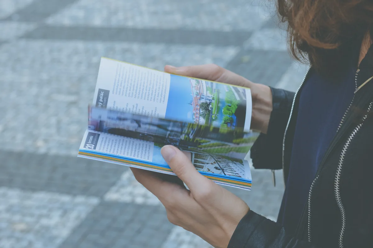 Traveler browsing a luxury travel guidebook outdoors