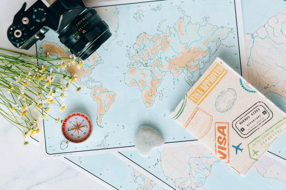 Travel planning flat lay with map, compass, and journal for flight booking