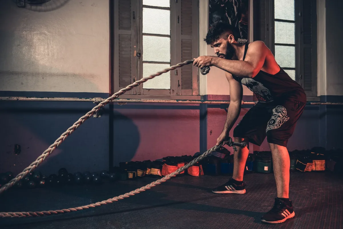 Man doing rope exercises in indoor crossfit gym