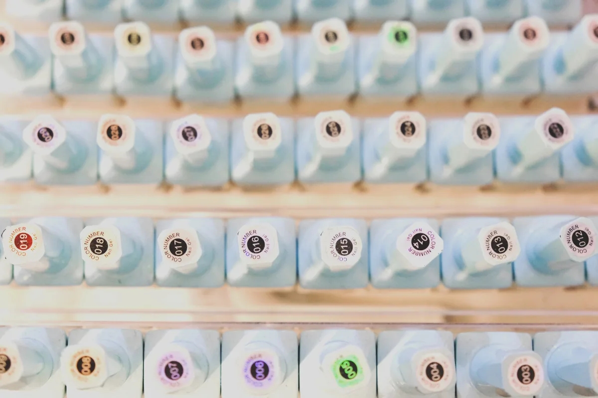Rows of colorful gel nail polish bottles arranged in a display — choosing between formats