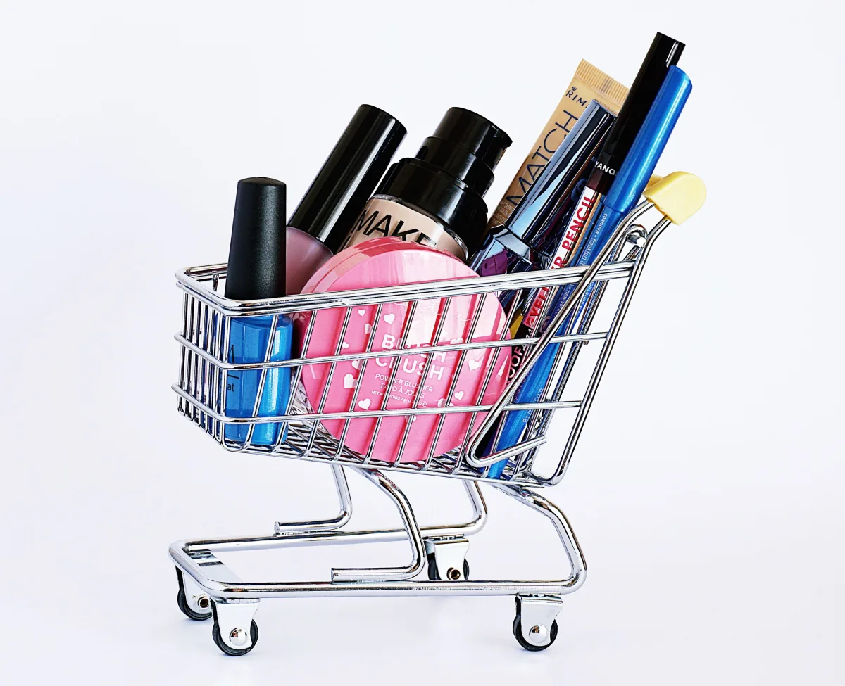 Miniature shopping cart filled with cosmetics
