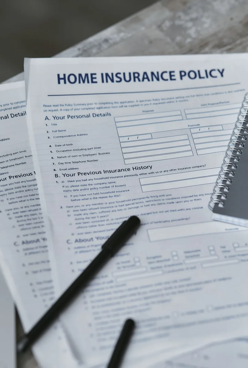 Home insurance policy form and notebook on desk — flatlay top view